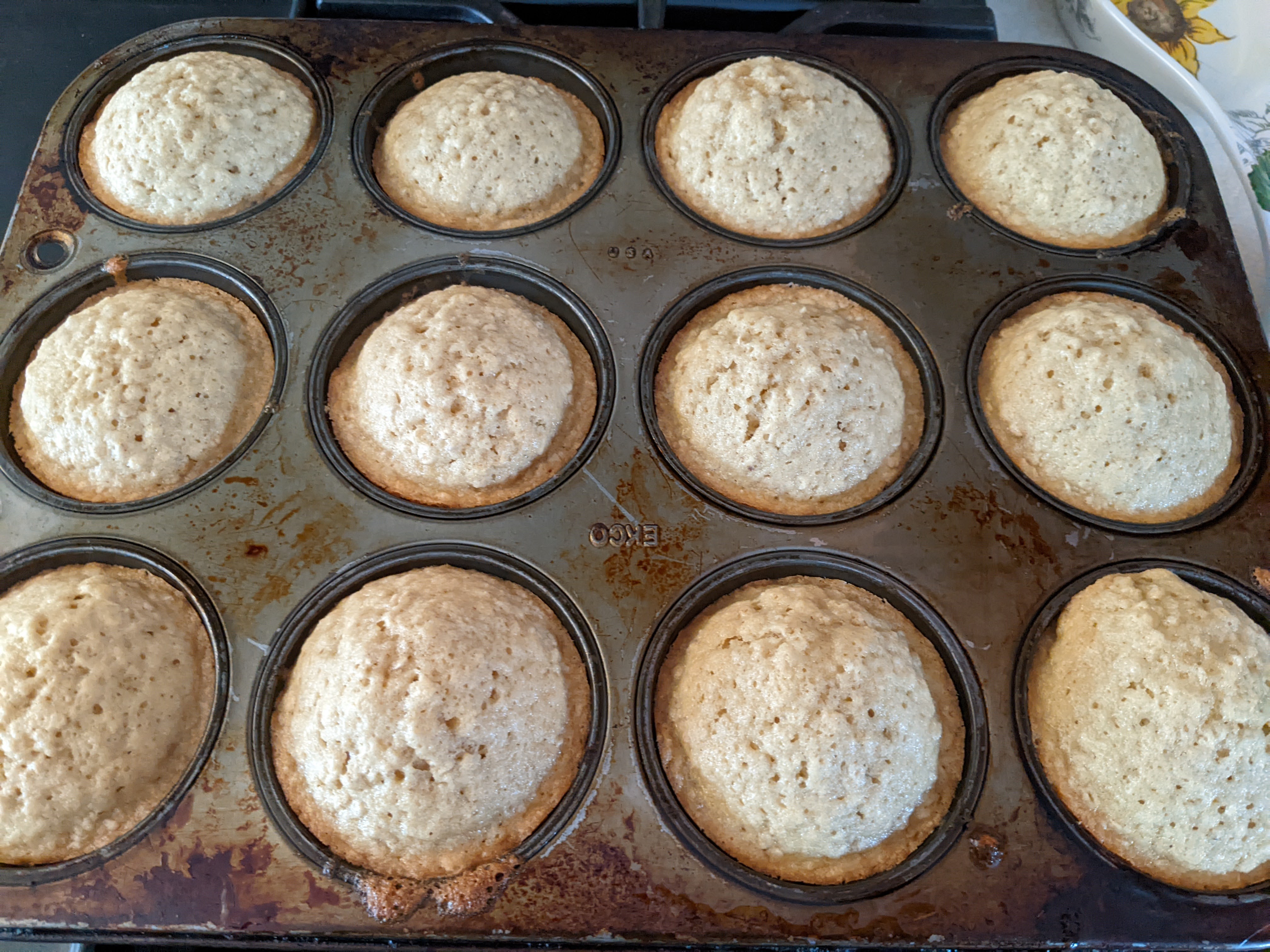 Very pale oatmeal chocolate chip muffins in a 12 count muffin tin.